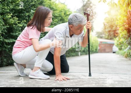 Asiatischer älterer Mann fiel zu Hause im Hinterhof durch Myasthenie (Muskelschwäche) und die Krankenschwester kam, um Unterstützung zu helfen. Konzept der alten elderl Stockfoto