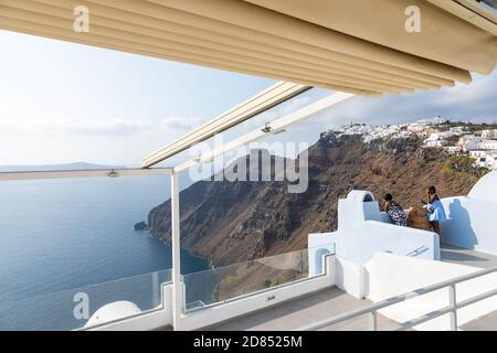 Fira, Santorini Island, Griechenland - 18. September 2020: Frauen auf der Terrasse mit Blick auf die Caldera. Stockfoto