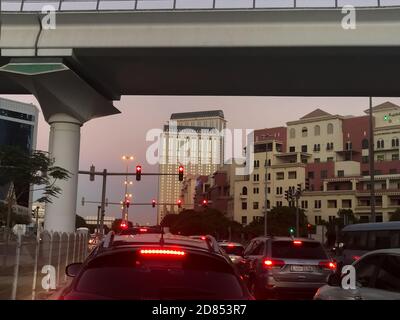 Dubai, Vereinigte Arabische Emirate - 15. Oktober 2020: Fahrzeuge hielten an einer roten Ampel, an einer belebten Kreuzung in Dubai in der Dämmerung. Stockfoto