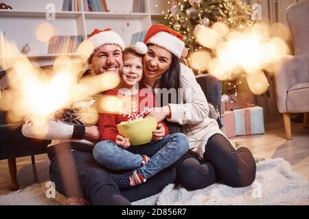 Glückliche Familie drinnen in weihnachtsmützen haben Spaß zusammen und Wir feiern das neue Jahr Stockfoto