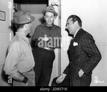 HUMPHREY BOGART und GEORGE FLOSS plaudern vor dem Ankleideraum mit dem Set-Besucher GEORGE BRENT am Set Candid während der Dreharbeiten von THEY DRIVE BY NIGHT 1940 Regisseur RAOUL WALSH Associate Producer Mark Hellinger Executive Producer Hal B. Wallis Warner Bros Stockfoto