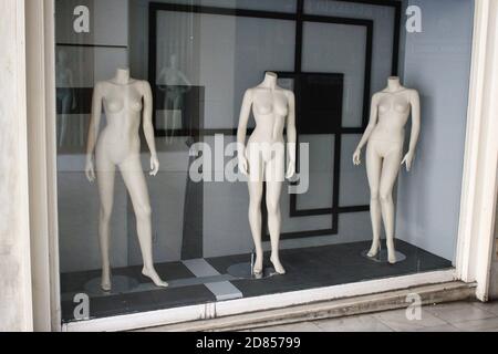 Das Fenster von leerem Bekleidungsgeschäft im Handelszentrum von Athen, mit Schaufensterpuppen im Display - Athen, Griechenland, 9. Oktober 2020. Stockfoto