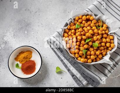 Würzige gebratene Kichererbsen. Vegane gesunde Snacks. Grauer Betonhintergrund, Kopierraum, horizontales Bild Stockfoto