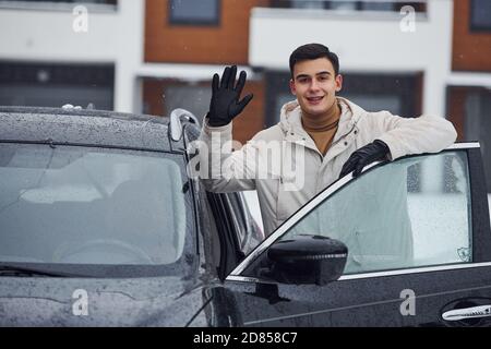Mann mit weihnachtsbaum, der auf der Leiter des Gebäudes steht Stockfoto