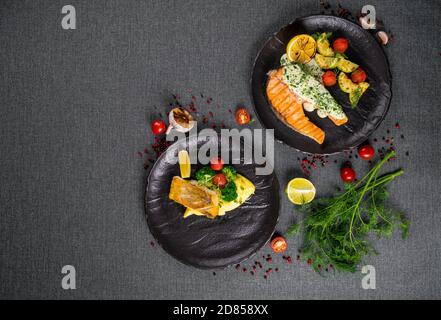 Zwei gegrillte Lachssteaks mit Gemüsemischung in einem Platte auf einem Holztisch Stockfoto