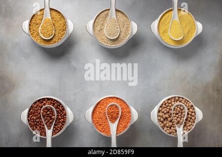 Verschiedene Getreide in Schalen (Couscous, Bohnen, Quinoa, Bulgur, Linsen, Kichererbsen). Gesunde Ernährung, Ernährungskonzept. Platz für Text, Draufsicht, Banner. Stockfoto