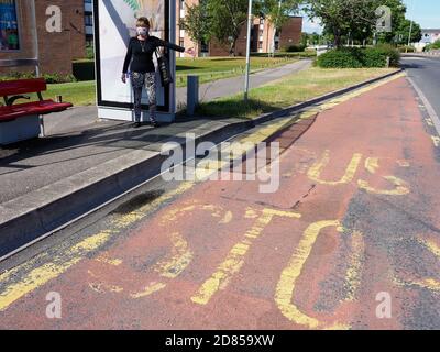 Poole, Dorset, Großbritannien. Juni 2020. Eine Frau, die eine Schutzmaske trägt, fährt während der Reisebeschränkungen in Covid an einer Bushaltestelle in den Bus. Stockfoto