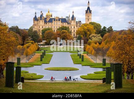 27. Oktober 2020, Mecklenburg-Vorpommern, Schwerin: Radfahrer sind unterwegs im Park vor dem Schweriner Schloss, das bunt mit Herbstblättern ist. Foto: Jens Büttner/dpa-Zentralbild/dpa Stockfoto