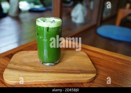 Nahaufnahme Glas Iced Matcha Grüntee auf Holz Fachtisch Stockfoto