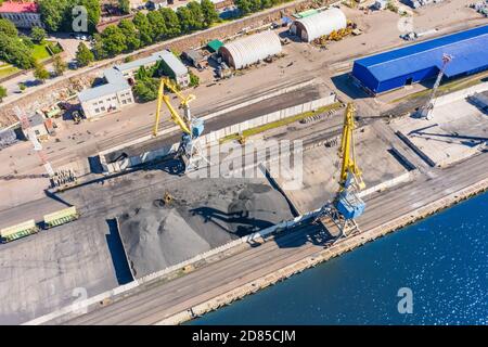 Verladung Kohlebergbau im Hafen auf Frachtschiff mit Kran Eimer Zug. Luftaufnahme von oben Stockfoto