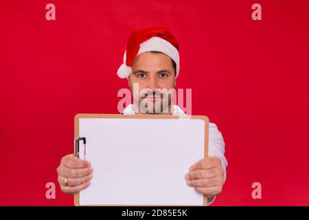 Unrasiert männlichen Arzt in Santa Claus Hut hält leere Zwischenablage Modell Stockfoto