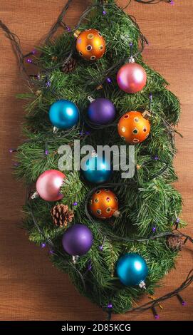 Luftaufnahme der Weihnachtsdekoration mit Kugeln, Lichter und Kiefer auf einem hölzernen Hintergrund. Draufsicht Hintergrund Stockfoto