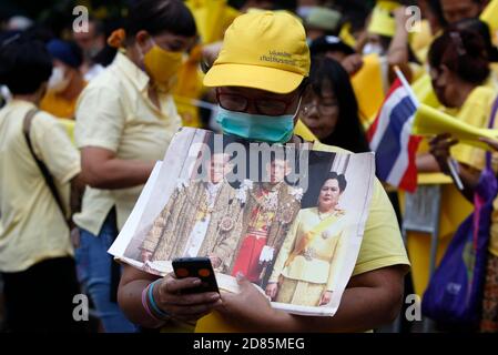 Bangkok, Thailand. Oktober 2020. Ein Pro-Royalist mit Porträts im Lumpini-Park während der Demonstration.Pro-Royalisten in gelben Hemden, während sie Porträts der thailändischen Königsfamilie während einer regierungsfreundlichen und monarchaischen Kundgebung hielten, die den Schutz der Monarchie im Lumpini-Park in Bangkok forderte. Kredit: SOPA Images Limited/Alamy Live Nachrichten Stockfoto