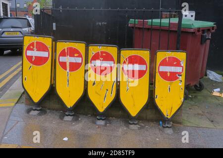 Fünf Hinweisschilder auf der Straße standen an der Mülltonne. Stockfoto