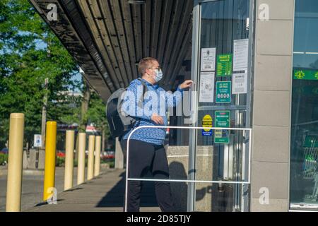 Toronto, Ontario, Kanada, August 2020 - Erwachsene Frau, die während einer covid Pandemie mit einer Gesichtsmaske in einen Lebensmittelladen geht Stockfoto