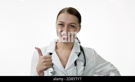 Glücklich attraktive Arzt mit Lachen zeigt wie Zeichen auf weiß Hintergrund Stockfoto