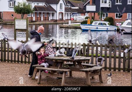 Familie essen Fisch und Chips auf Picknick-Bank, Wroxham, Norfolk, England, Großbritannien Stockfoto