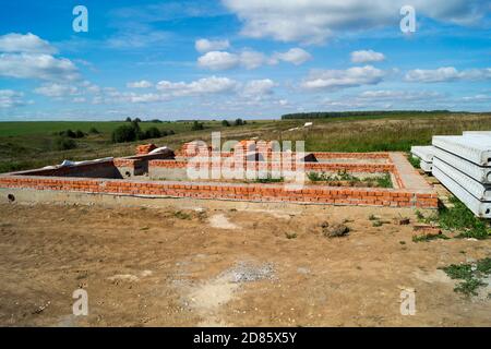 Der Bau des Fundaments für den Bau im Feld auf dem Hintergrund blauen Himmel. Jahr Landschaft am Sonnentag Stockfoto