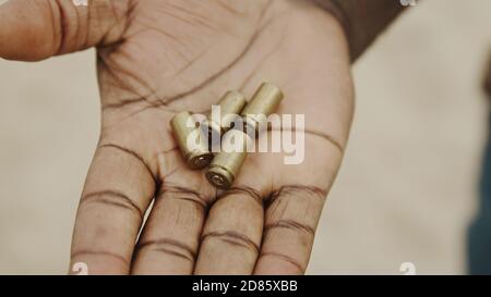 Nahaufnahme, schwarze Mann Hände Zählen gebrauchte Kugeln. Viele Bullet-Fälle wurden von einer Hand zur anderen übertragen. Hochwertige Fotos Stockfoto