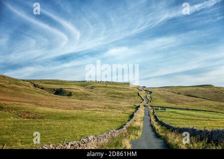 Himmel und Sonnenschein auf dem Gipfel des berühmten Radhügels, Park Rash, ruhige Landstraße aus Kettlewell. Wharfedale, North Yorkshire Stockfoto