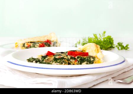 Stück Pie mit Spinat und Tomaten. Vegetarische Küche. Satly-Kuchen. Stockfoto