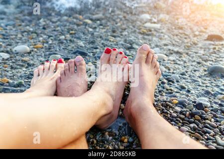 Urlaub. Beine aus der Nähe Ruhe am Strand des Meeres, genießen Sie die Sonne. Reisekonzept Stockfoto