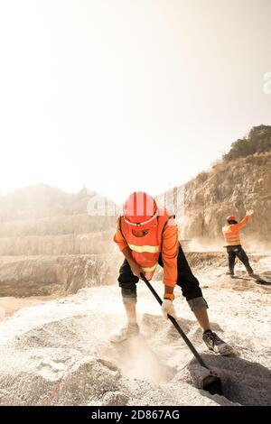 Bergleute arbeiten mit Bergbau-Tool in staubigen und heißen Backen, Bergbau und Sommer heißen Sonne im Hintergrund. Harte Arbeit Konzept. Rauschen, Körnung. Stockfoto