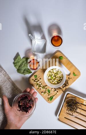 Chinesische Teeparty. Trockene Granulate verschiedener Teesorten. Flatlay, Draufsicht. Kräutertee, auf weißem Hintergrund. Vertikales Foto Stockfoto