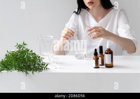 Der Wissenschaftler, Dermatologe testet das organische Naturkosmetikprodukt im Labor. Fläschchen, Laborflaschen aus Glas. Beauty kosmetische Forschung und Entwicklung Konzept. Stockfoto