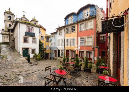 Porto, Portugal - 19. November 2019: Cafeteria im Freien auf einem Platz mit bunten Häusern im historischen Zentrum von Porto. Stockfoto