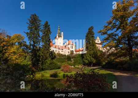 Pruhonice, Tschechische Republik - Oktober 25 2020: Blick auf die berühmte romantische Burg auf einem grünen Hügel in einem Park mit Bäumen umgeben. Sonniger Herbst Stockfoto