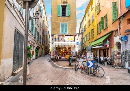 Souvenirläden und Cafés an einer der vielen scharfen Ecken und Kurven in der kurvigen, verwinkelten Altstadt von Vieux Nice, Frankreich, an der französischen Riviera. Stockfoto