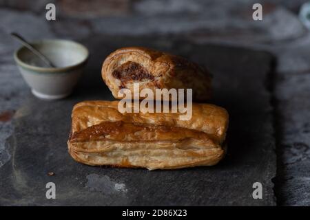 Frisch gebackene Wurstbrötchen auf Schiefer Stockfoto