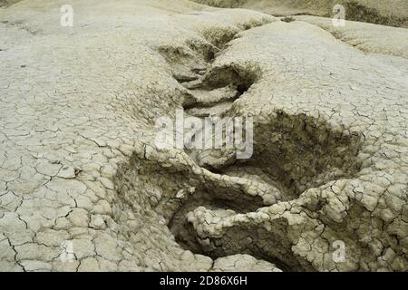 Gewellter Wasserkanal in trockener Bodenstruktur. Die Berca Mud Volcanoes ist ein geologisches und botanisches Reservat. Kleine vulkanförmige Strukturen verursacht b Stockfoto