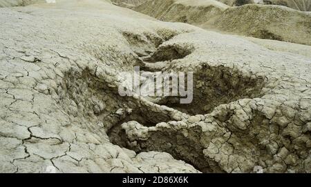 Gewellter Wasserkanal in trockener Bodenstruktur. Die Schlammvulkane sind ein geologisches und botanisches Reservat in Paclele Mari bei Buzau, Rumänien. Kleine volc Stockfoto