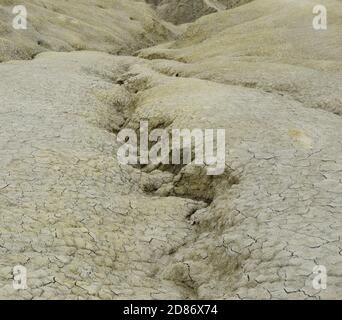 Gewellter Wasserkanal in trockener Bodenstruktur. Die Berca Mud Volcanoes ist ein geologisches und botanisches Reservat. Kleine vulkanförmige Strukturen verursacht b Stockfoto