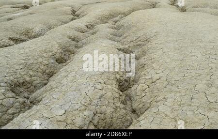 Gewellter Wasserkanal in trockener Bodenstruktur. Die Berca Mud Volcanoes ist ein geologisches und botanisches Reservat. Kleine vulkanförmige Strukturen verursacht b Stockfoto