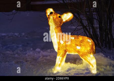 Beleuchtung Acryl Hirsch Figur, Dekoration von kleinen Rentieren beleuchtet im Winter Abend Stockfoto