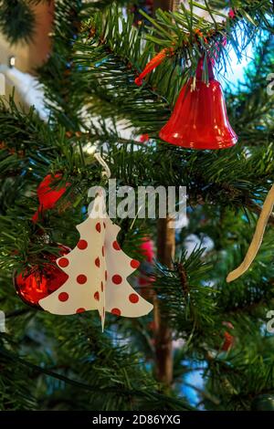 Neujahr Karte mit Spielzeug auf Fischgräten, Pappfigur von Weihnachtsbaum und Metall rote Glocke hängen auf Neujahr Baum Stockfoto