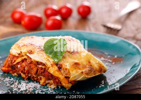 Portion italienische Lasagne auf einem blauen Teller Stockfoto