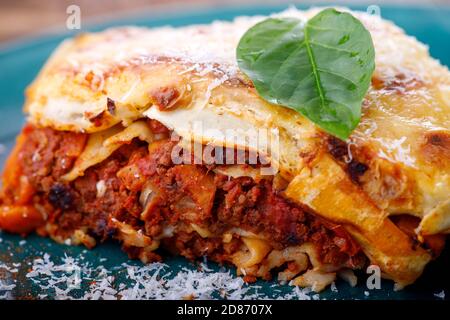 Portion italienische Lasagne auf einem blauen Teller Stockfoto