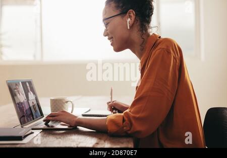 Frau, die sich online mit Kollegen bei einem Videoanruf trifft und von zu Hause aus arbeitet. Geschäftsfrau in einem Videokonferenzanruf. Stockfoto