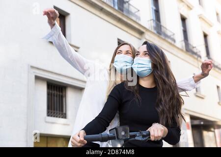 Zwei junge Mädchen mit medizinischen Masken Spaß im Urlaub während der Covid-19 Periode. Stockfoto