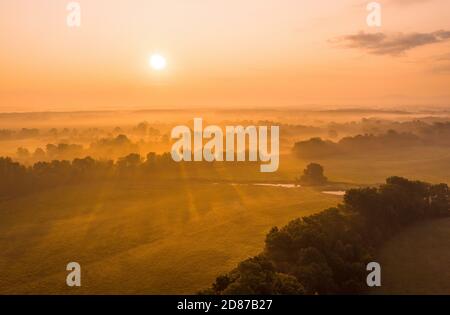Sonne steigt im Sommer über dem Auenwald von der Drohne Stockfoto