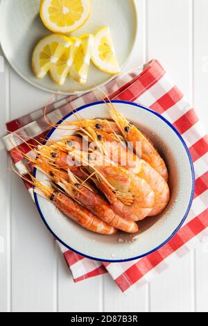 Gekochte Tigergarnelen in Schüssel auf weißem Tisch. Draufsicht. Leckere Garnelen. Stockfoto