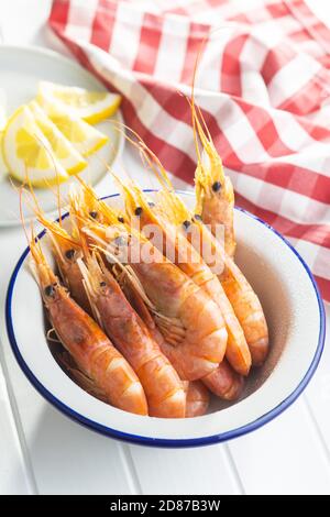 Gekochte Tigergarnelen in Schüssel auf weißem Tisch. Leckere Garnelen. Stockfoto