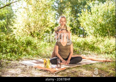 Professionelle Masseurin bietet eine gründliche Massage auf dem Boden. Stockfoto