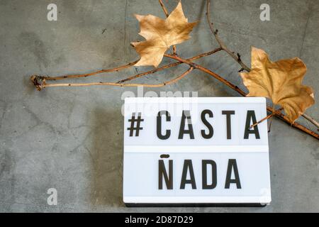 Dunkler Halloween Hintergrund mit trockenen Ästen und goldenen Zierblättern, Text Castañada. Stockfoto