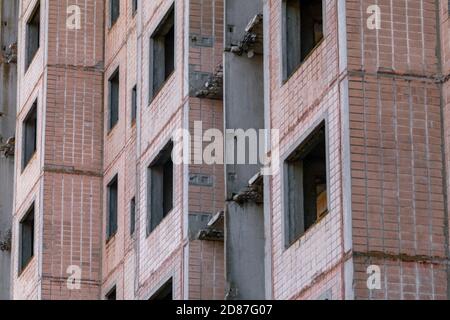 Hohe mehrstöckige verlassene sowjetische Gebäude geflieste Fassade. Verwitterte Wohnsiedlung, unvollendete Stadt der Atomwissenschaftler in Birky, Ukraine Stockfoto