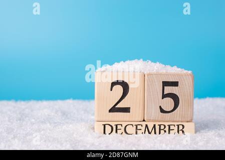 Nahaufnahme Foto-Bild von Holzkalender zeigt den 25. Von dezember steht auf weißem weichem Schnee Stockfoto